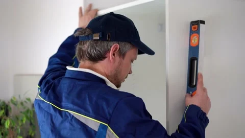 Man installs cabinet, level measures the position of the walls of the chipboard 스톡 동영상 202303033
