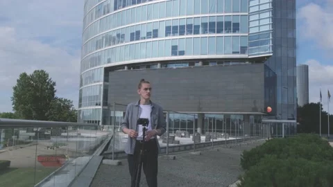 Man installs camera on tripod and looks around in street Stock Footage 139797708