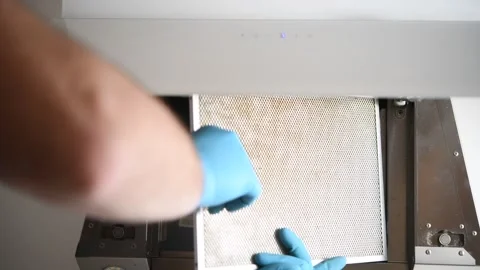 A man installs a cleaning filter in a range hood. Video stock 299721323