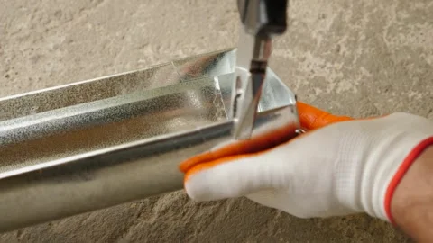 A man installs a metal gutter system. Water drainage system of the house. Video stock 288073701