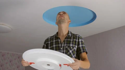 A man installs a modern led ceiling ligh... | Stock Video | Pond5