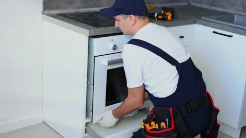 Man installs an oven after assembling the kitchen. Stock Footage 266888390