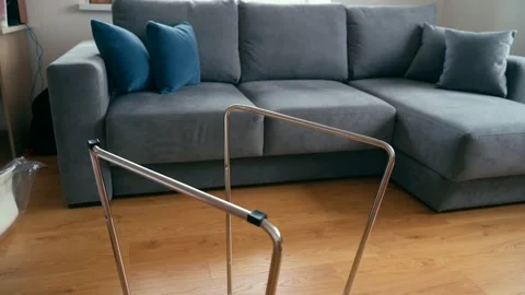 A man installs plastic pads on the chrome legs of a chair. Video stock 142053502