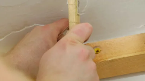 Man installs plastic wall anchor into wooden bar with hammer Video stock 304404067
