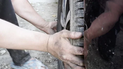 A man installs a wheel on a car Stock Footage 155648656