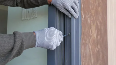 Man installs a window in a house during daylight hours Stock Footage 342893098