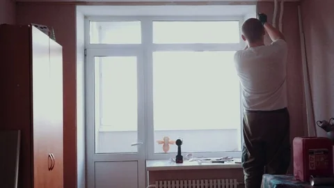 The man installs the windows Stock Footage 81500853