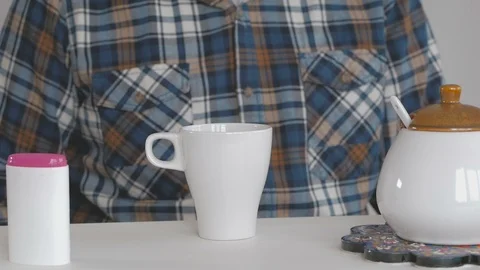 A man instead of sugar adds sweetener to coffee Stock Footage 100975367