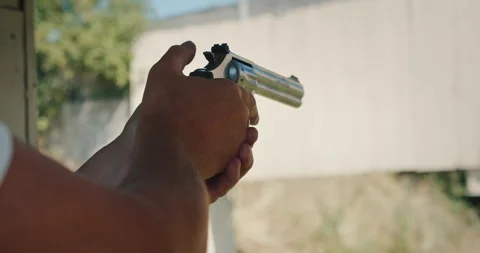 Man instructor demonstrating revolver handling at an outdoor shooting range Stock Footage 313730679