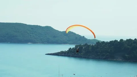 Man with instructor flies with parachute above the sea and mountains. Extreme Stock Footage 201412687