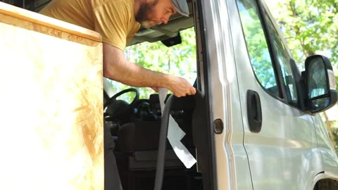 Man insulating a camper van from the cold in his camper van customization b.. Stock Footage 274070711