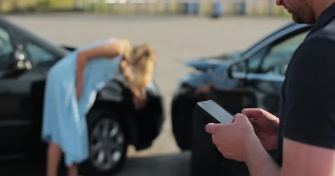 Man insurance agent inspects damage to a woman car and makes notes on a Stock Footage 248711925