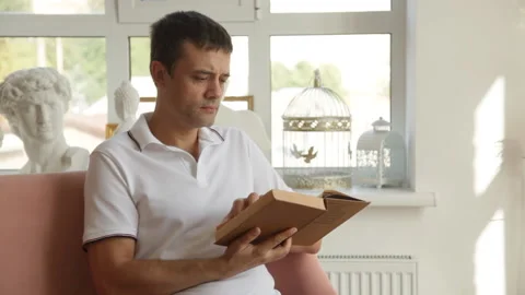 The man is intently flipping through the pages of an old book and reading it Stock Footage 205611737