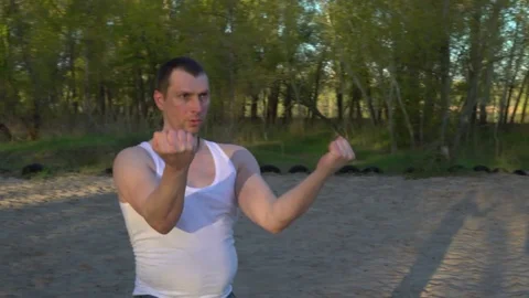 The Man Intently Performs the Kata of Karate at Dawn,standing on the Sand Stock Footage 75156269