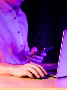 Man interacting with devices featuring holographic pill icon in neon purple Stock Photos