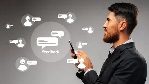 Man interacting with feedback icons on a mobile device in a professional setting Stock Photos