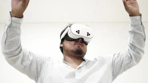 Man interacting with virtual reality headset on white background 스톡 동영상 309772415
