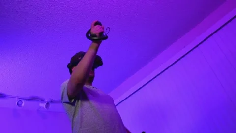 Man interacting with virtual reality using VR controllers Stock Footage 334086869