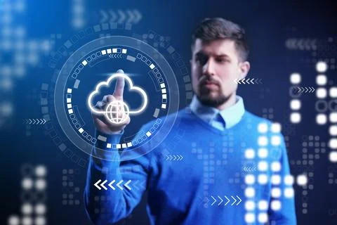 Man interacts with digital cloud interface in a modern workspace at evening time 写真素材