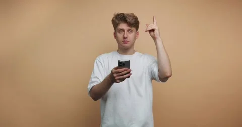 Man interacts with phone in four frames showing different expressions and g.. 動画素材 328247060