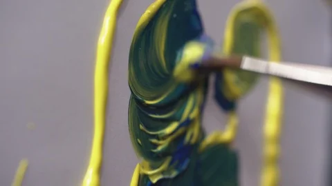 Man interferes with the color of the brush to get a blue color for the picture Stock Footage 124867452