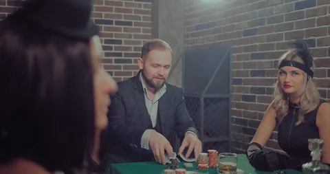 Man interferes with a deck of cards and looks at the participants in the game Video stock 105883580