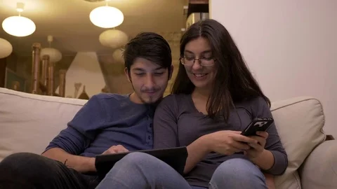 Man introducing data on tablet pc while the woman uses smartphone to dictate  Stock Footage 83047295