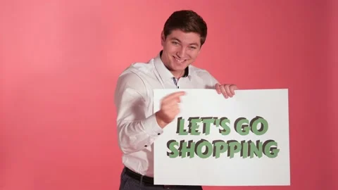 Man Invites Customers With "Let's Go Shopping" Sign, Studio Background Stock Footage 139613713