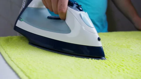 Man ironing bright cloth, camera movement Stock Footage 138601342