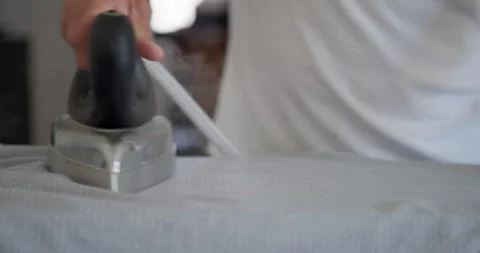 : A man is ironing clothes on an ironing board. Stock Footage 344308196