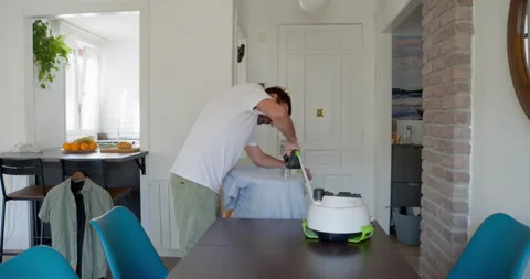 Man Ironing Tablecloth at Home: Stock Footage 344312017