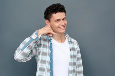 Man isolated on gray wall free style standing looking camera showing call Stock Photos