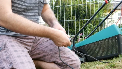 A man isolates a damaged mower cable Stock Footage 89870618