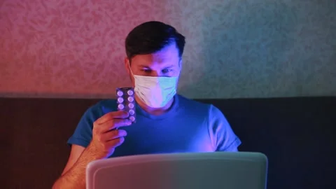 A man in isolation isolates on a laptop and drinks alcohol. Stock Footage 131460478