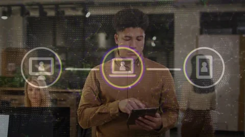 Man in IT office tapping tablet demonstrating network overlay with center node Stock Footage 334115587