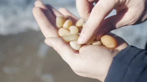 The man iterates over the stones in his hand Stock Footage 72106995