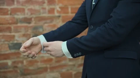 A man in a jacket adjusts the sleeves of his shirt Stock Footage 328299543