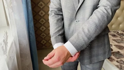 A man in a jacket adjusts the sleeves of his shirt Stockbeeldmateriaal 329091287