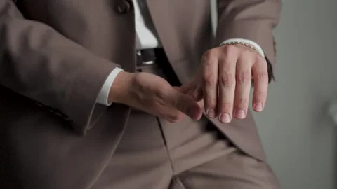 A man in a jacket adjusts the sleeves of his shirt Stock Footage 329094969