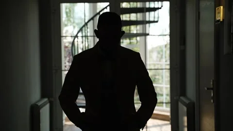Man in jacket and trousers walks down dark corridor Stock-Footage 332980463