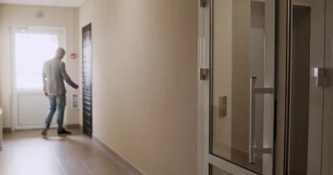 Man in jacket calmly opens door to apartment with keys Video stock 294602483