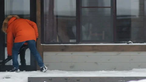 Man in jacket cleans track from snow Stockbeeldmateriaal 139734713