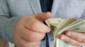 Man in a jacket counts money Stock Footage 86149100