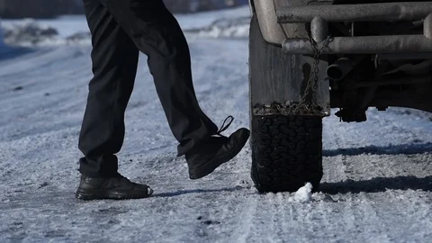 A man in a jacket gets out of the car on a winter road outside the city and i Video stock 99626004