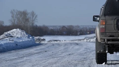 A man in a jacket gets out of the car on a winter road outside the city Stock Footage 100591161