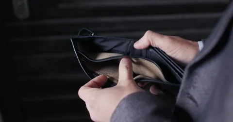 Man in jacket opens empty wallet on dark background Stock Footage 183547739