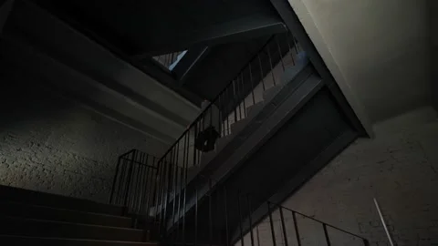 A man in a jacket quickly descends the stairs down in the apartment Stock Footage 205324328