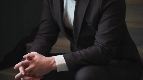 A man in a jacket sits and thinks about a big business project Stock Footage 328047828