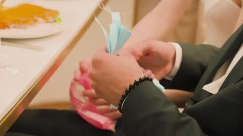 A man in a jacket sorts through ribbons with his hands at a table 스톡 동영상 329092462