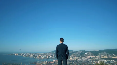 A man in a jacket stands on a hill Stock Footage 128747884